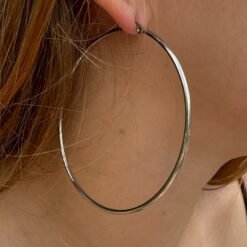 Extra large thin silver hoop earring, lightweight and waterproof, shown on a model.