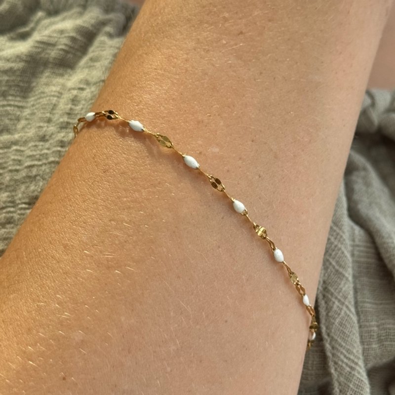 Gold chain bracelet with white beaded accents, minimalist and waterproof design.