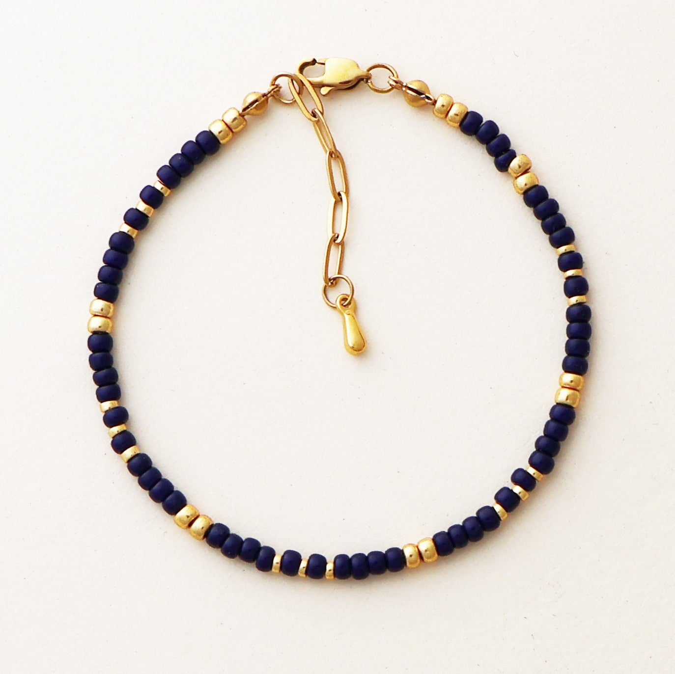 Close-up of the Cairo Navy Bracelet featuring navy Miyuki glass beads with gold accents and a gold clasp on a neutral background.