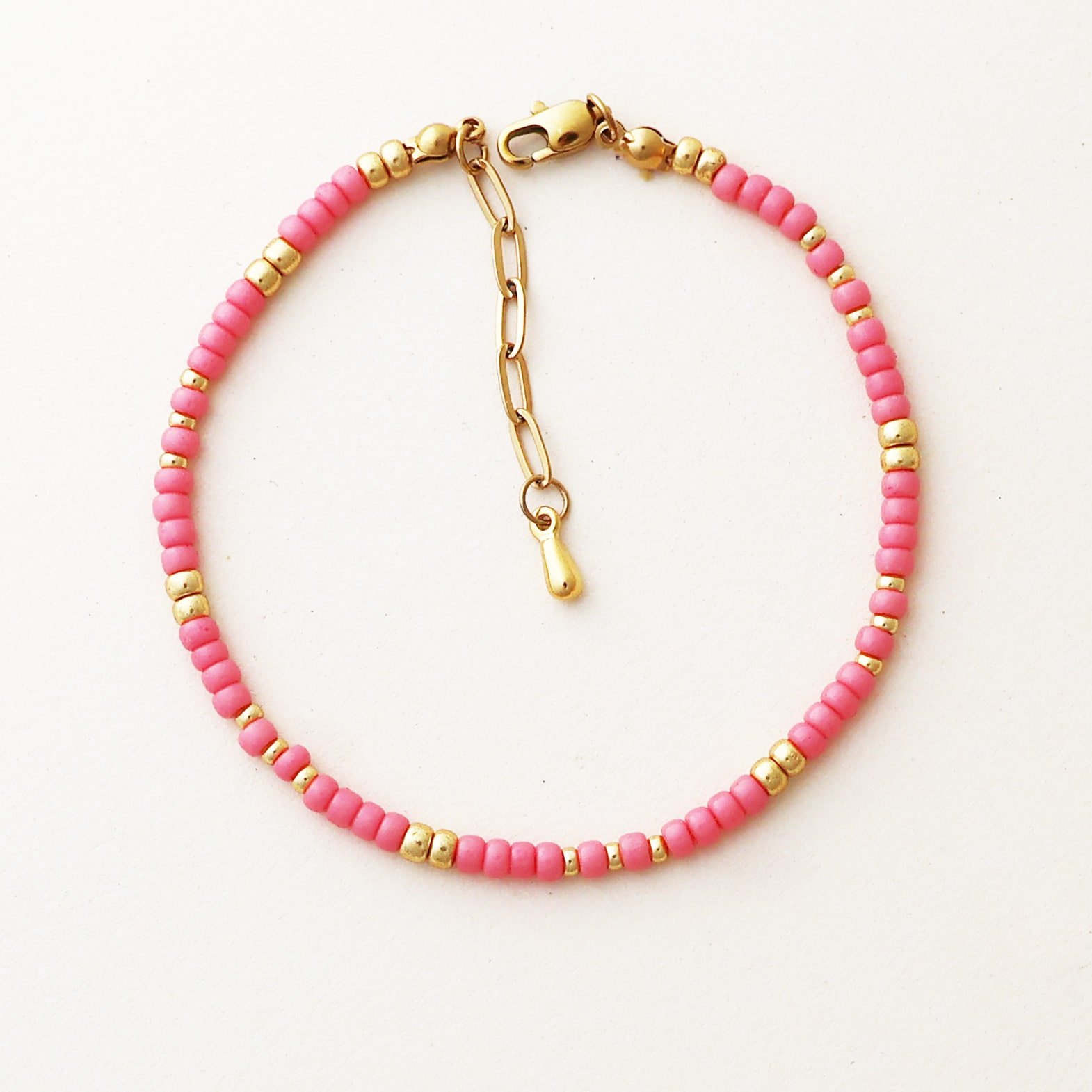 Close-up of the Cairo Pink Bracelet featuring soft pink Miyuki beads with gold accents and a gold clasp on a neutral background.