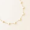 close-up of delicate gold chain necklace with spaced freshwater pearls